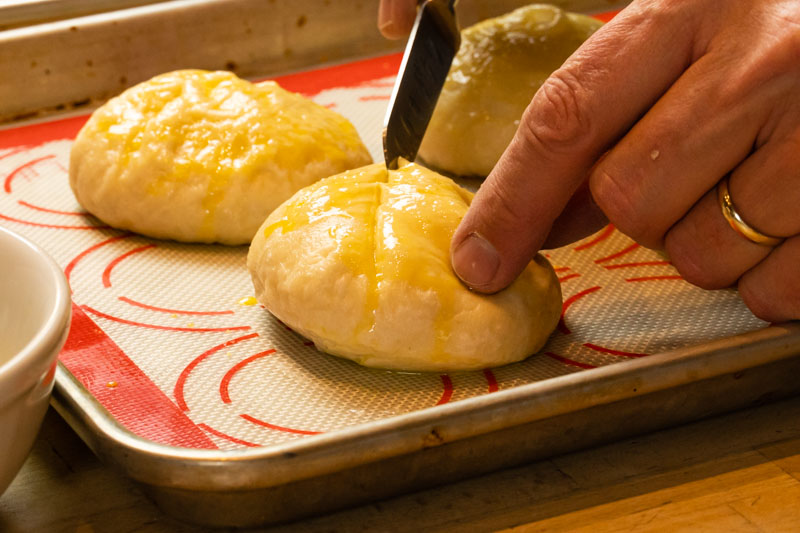 Scoring tops of pretzel buns