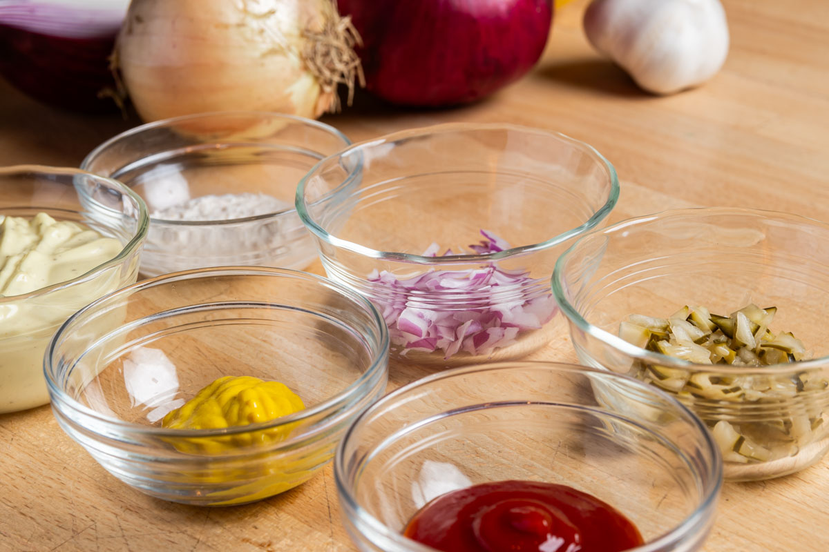 Cheeseburger sauce ingredients each in a clear glass bowl