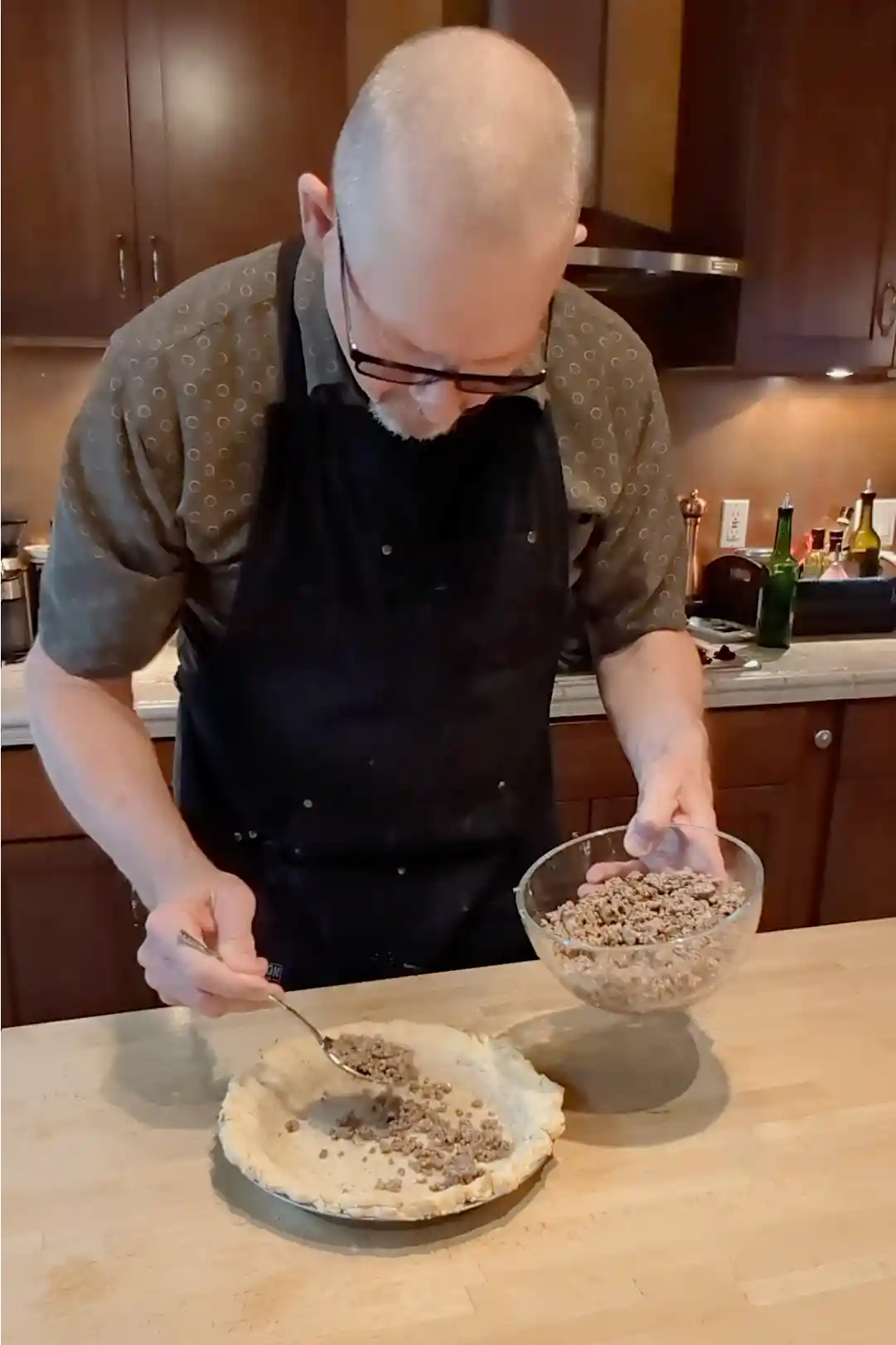 Cheeseburger Guru adding the ground beef to the bacon cheeseburger quiche pie crust.